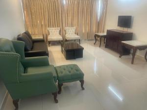 un soggiorno con divano, sedie e pianoforte di Royal Nest Premium-AS a Pune