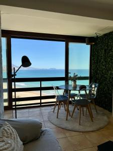 uma mesa e cadeiras num quarto com vista para o oceano em Vistas al Mar, Piscina y Playa em Alicante