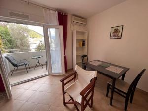 un soggiorno con tavolo e sedie e un balcone di Apartments "Helios" a Njivice