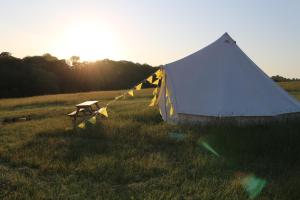 ein Zelt und ein Picknicktisch auf einem Feld in der Unterkunft Penn Meadow Farm in Buckinghamshire