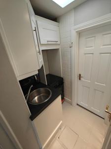 a small bathroom with a sink and a door at Delightful 3 Bed Dublin City House in Dublin