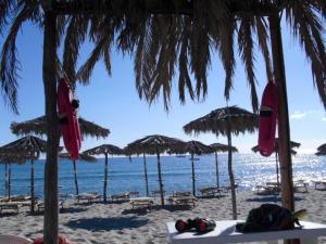 a beach with umbrellas and chairs and the ocean at Hotel Baia Cea in Bari Sardo