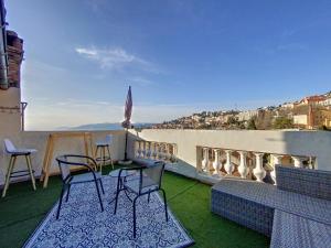 eine Terrasse mit Stühlen und einem Tisch auf dem Balkon in der Unterkunft Magnifique appartement vue mer et parking privé ! in Grasse