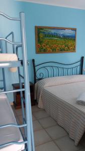 a bedroom with two beds and a painting on the wall at Hotel Baia Cea in Bari Sardo