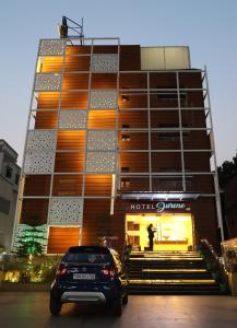 een gebouw waar een auto voor geparkeerd staat bij Hotel Durene in Bhubaneshwar