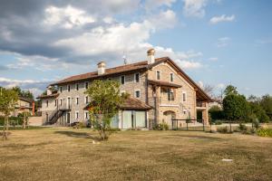 una gran casa de piedra con un patio delante en Atmosfere Charme & Country, en Udine