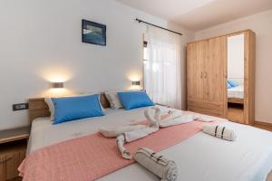 a bedroom with two beds with towels on them at Guesthouse Romana in Cres