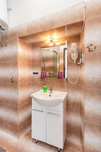 bagno con lavandino bianco e specchio di Guesthouse Romana a Cres