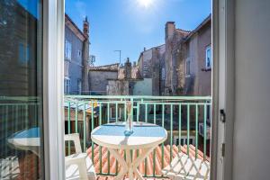 a balcony with a table and a view of a street at Guesthouse Romana in Cres