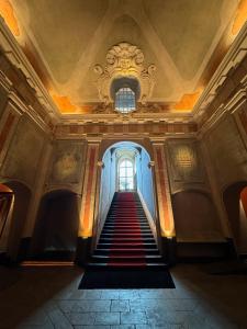a hallway with stairs in a building with a window at Hotel Palazzo Durazzo Suites in Genoa