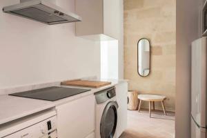 a white kitchen with a washing machine in it at Suite 3 in Mahón
