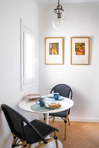 a dining room with a white table and chairs at Suite 3 in Mahón