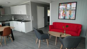 un soggiorno con divano rosso e tavolo di Lofothytter a Offersøya