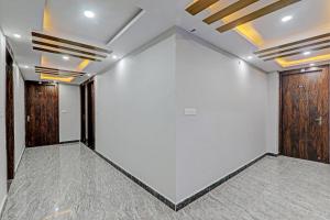 Cette chambre est dotée de murs blancs et de portes en bois. dans l'établissement Hotel RK Grand, à Lucknow