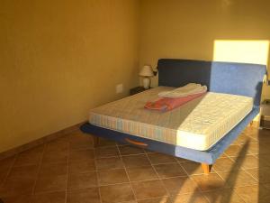 a bed with a blue frame in a room at Borgo Spiaggia Isola Rossa in Isola Rossa