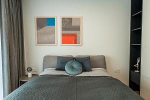 una camera da letto con un letto con un cuscino blu di Luxury city center apartment - parking included a Košice