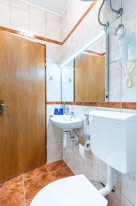 ein Bad mit einem WC, einem Waschbecken und einem Spiegel in der Unterkunft Guesthouse Romana in Cres