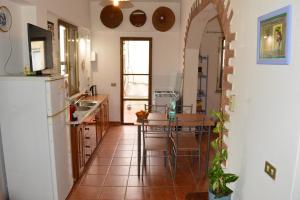 een keuken met een tafel en stoelen in een kamer bij Stefania Guest House in Giba