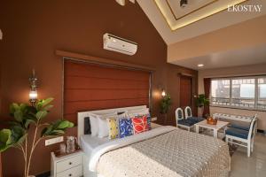 a bedroom with a large bed and a balcony at EKOSTAY Luxe - Highland Villa in Panchgani