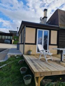 un banc sur une terrasse en bois devant une maison dans l'établissement Studio L'audrerie., à Saint-Pardoux-Corbier
