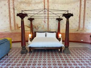 a bedroom with a canopy bed with two white pillows at Il Sogno di Elisa in Lucca