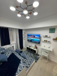 a bedroom with a bed and a tv on the wall at Gellybean Homestay ( AZURE North Residence / Staycation) in San Fernando