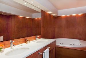 a bathroom with two sinks and a bath tub at Four Points by Sheraton Padova in Padova