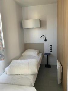 two beds in a small room with white walls at Camping Oasis Middelkerke Louisiane I, II, III, IV in Ostend