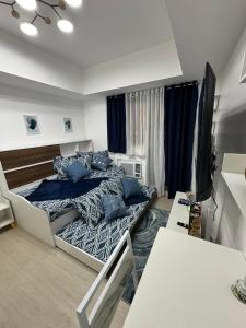 a bedroom with a bed with blue pillows on it at Gellybean Homestay ( AZURE North Residence / Staycation) in San Fernando