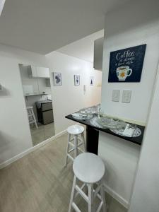 a kitchen with a counter and stools in a room at Gellybean Homestay ( AZURE North Residence / Staycation) in San Fernando