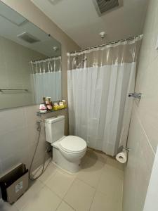 a bathroom with a white toilet and a shower at Gellybean Homestay ( AZURE North Residence / Staycation) in San Fernando