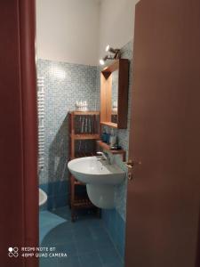 a bathroom with a white sink and blue tiles at Casa di Ermes in Sestri Levante