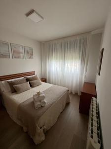 una camera da letto con un letto e un animale di peluche di Apartamento El Viaducto en Redondela a Redondela