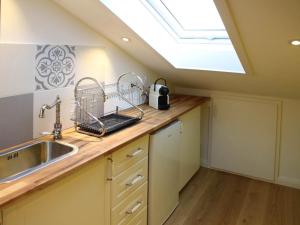 a kitchen with a sink and a skylight at Ferienwohnung Villa sorglos Suite | Chiemgau Karte in Grassau +15 photos