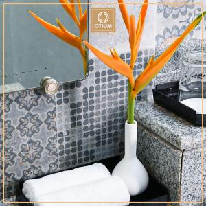 a white vase with a plant in a bathroom at Otium Goa Resort by The Oterra in Porvorim