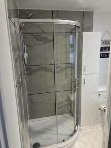 a shower with a glass door in a bathroom at Modern 2 Berth Seaside Studio Apartment On Ground Floor In Hemsby, Ref 99011ws in Great Yarmouth