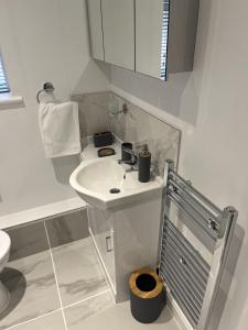 a white bathroom with a sink and a toilet at Modern 2 Berth Seaside Studio Apartment On Ground Floor In Hemsby, Ref 99011ws in Great Yarmouth