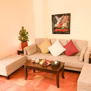 Otium Goa Resort by The Oterra في بورفوريم: غرفة معيشة مع أريكة وطاولة