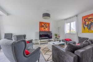 uma sala de estar com sofás e uma televisão de ecrã plano em Villa Elaïa maison Familiale Omaha Beach em Saint-Laurent-sur-Mer