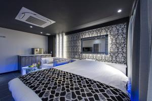 1 dormitorio con 1 cama blanca grande y espejo en HOTEL COSTA RESORT Omiya, en Saitama
