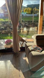 a living room with a window with a view of a yard at Drevenica RELAX in Makov