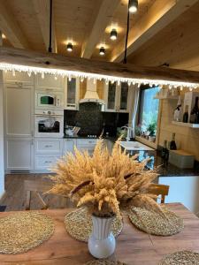 una cocina con una mesa de madera y un jarrón con flores en Drevenica RELAX en Makov