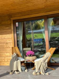 a porch with two chairs and a table with flowers at Drevenica RELAX in Makov