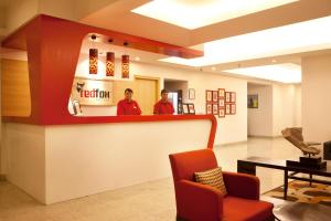 two men standing behind a counter in a waiting room at Red Fox Hotel, East Delhi in New Delhi