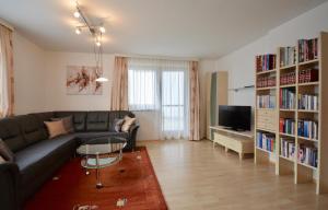 a living room with a couch and book shelves at Ferienwohnung Sonnenhang in Nußdorf