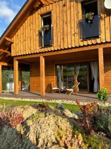 uma grande casa de madeira com janelas e um pátio em Drevenica RELAX em Makov