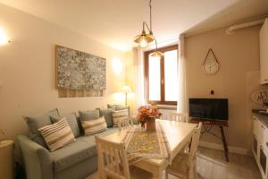 ein Wohnzimmer mit einem Sofa und einem Tisch in der Unterkunft Violetta Maison, elegante e romantica a Salo’ in Salò