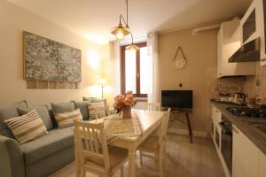 eine Küche und ein Wohnzimmer mit einem Tisch und einem Sofa in der Unterkunft Violetta Maison, elegante e romantica a Salo’ in Salò