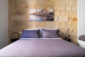- une chambre avec un lit et un mur en briques dans l'établissement Pane e Pomodoro, à Bari
