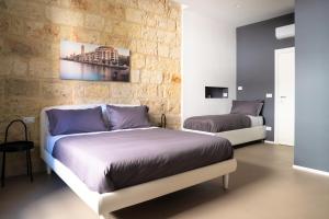 - une chambre avec 2 lits et un mur en briques dans l'établissement Pane e Pomodoro, à Bari